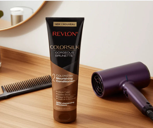 Revlon Colorsilk Gorgeous Brunette conditioner tube on wooden vanity with purple hair dryer and comb