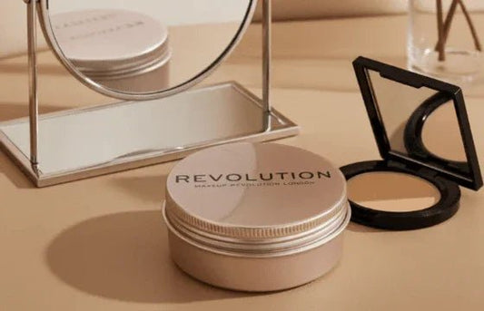 Makeup Revolution Balm Glow natural nude balm and compact powder with mirror on beige surface